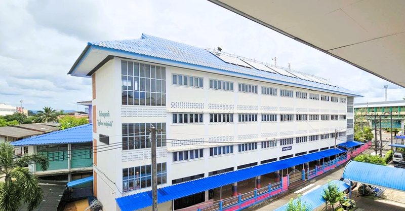 School building with rooftop solar panels seen from the ground