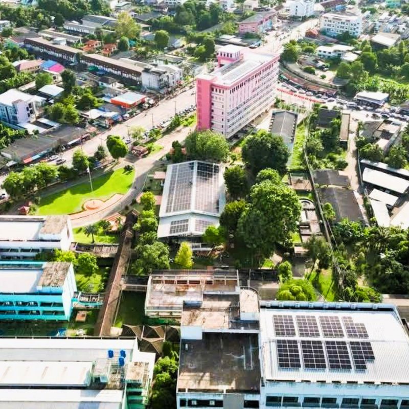 Aerial view of rooftop solar panels on buildings in a Thai town