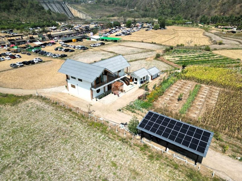 Aerial view of the farmhouse and ground-mounted array