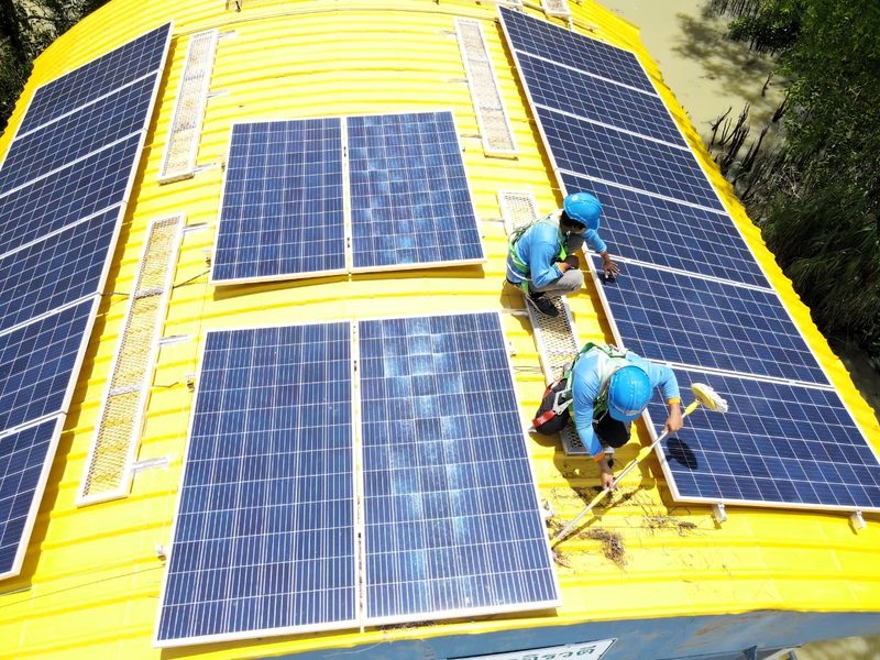 Solar panels on the boat roof with a technician at work