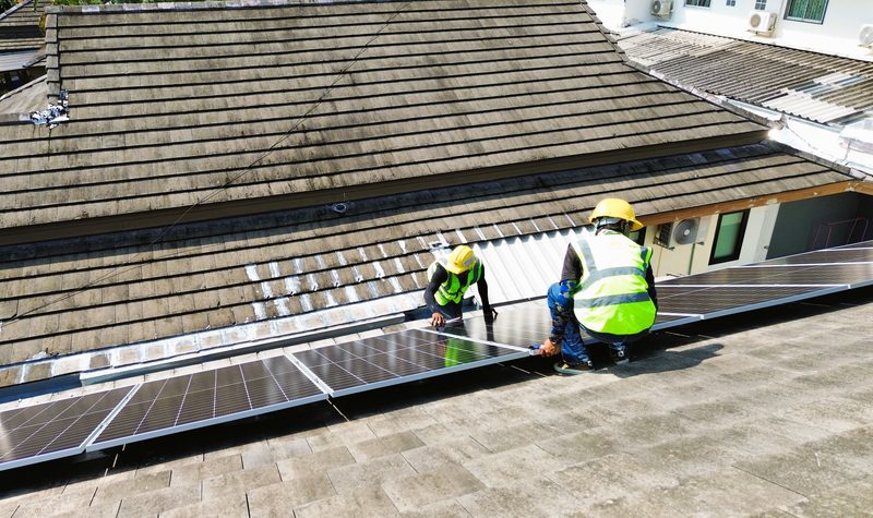Technicians working on the tiled roof